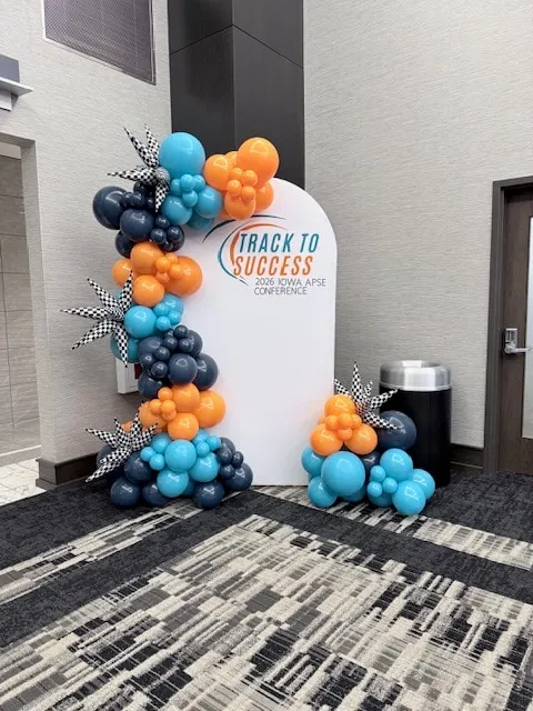 Arch stand in navy, teal and orange with checkered starbursts for a conference
