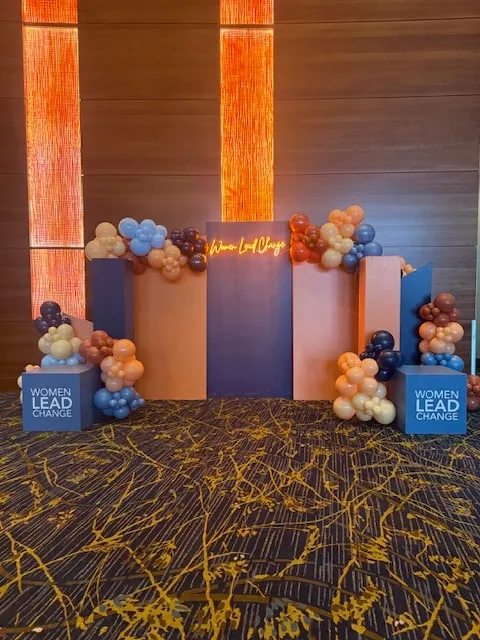 Stage backdrop clusters in peach, blue and burgundy for a leadership conference